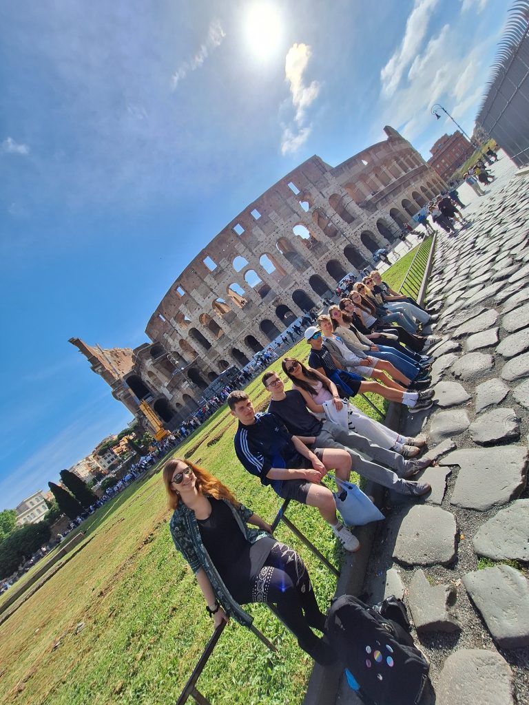 Eine Reisegruppe von Schüler*innen vor dem Kolosseum in Rom